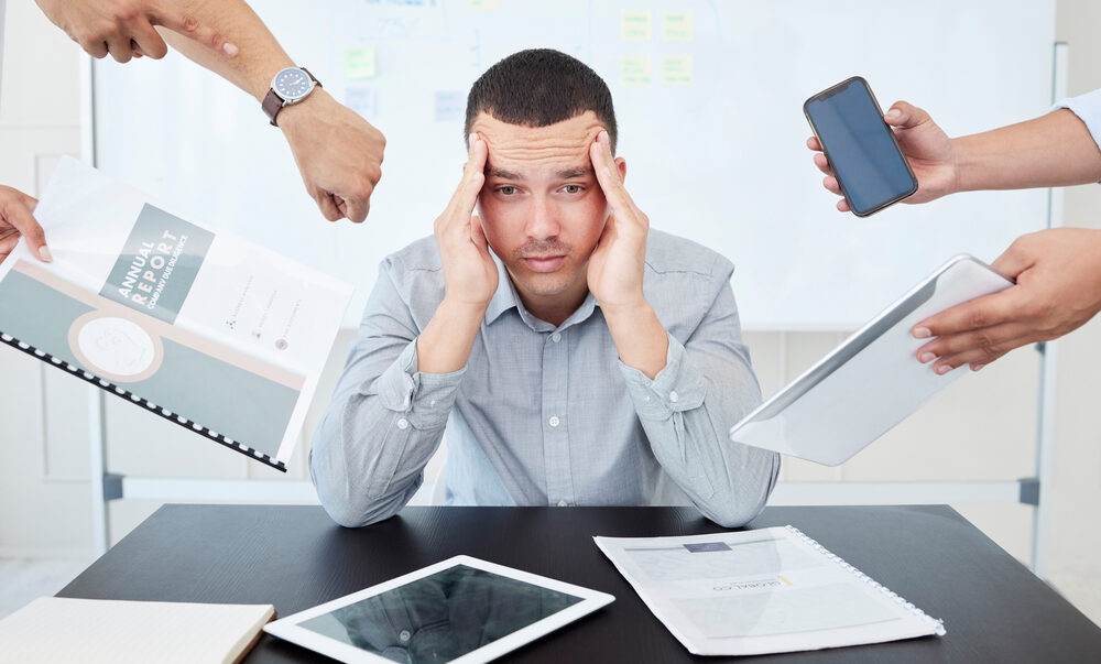 Man, stress and hands for multitask in office, documents and sad for chaos at desk. Overworked, burnout or overwhelmed by deadline for accountant person, manager and workplace for annual report audit.